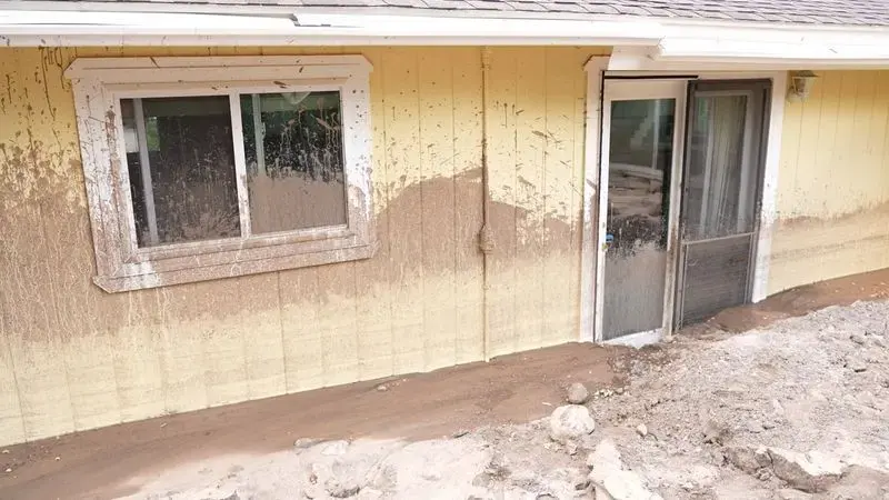 Mud line on the stucco wall of an Inland Empire home after foothill storm runoff