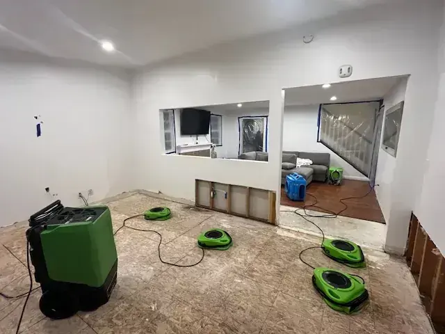 Air movers and an LGR dehumidifier drying a gutted room to the S500 goal in Fontana